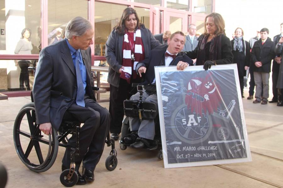 Principal Sandy Compian, Governor Greg Abbott, and Barbara Hadley congratulate senior Archer Hadley during the debut of the automatic doors with a special poster.