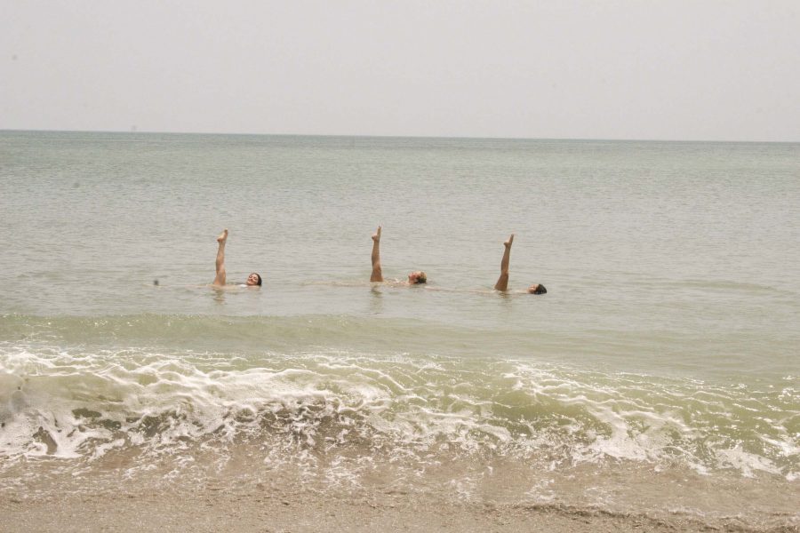 Olivia Heinze and her team members perform practice synchronized swimming at the beach. 