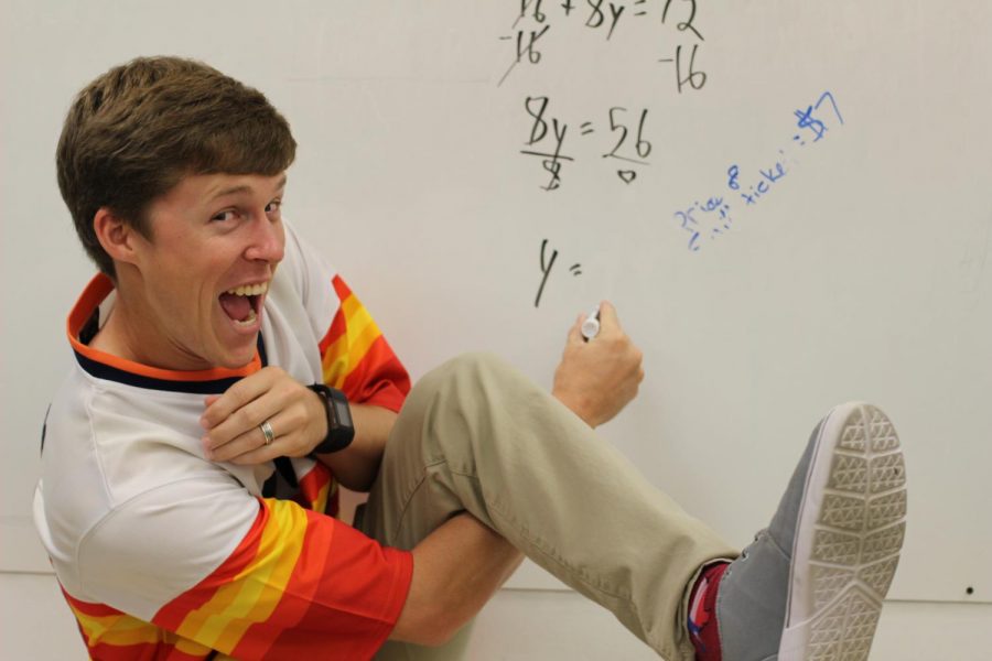 Math+teacher+Alexander+Eberly+solves+a+math+problem+on+the+board+while+showing+his+silly+side.+