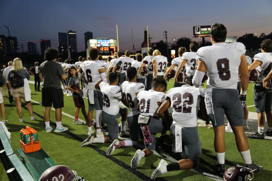 Varsity football players take a knee during the national anthem during the game against McCallum on Oct. 5.